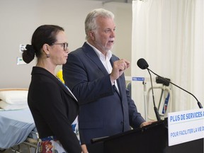Quebec Liberal leader Philippe Couillard speaks at a news conference alongside Jean-Lesage candidate Gertrude Bourdon while visiting an auxiliary nursing school on Aug. 30, 2018, in St-Georges, Que.