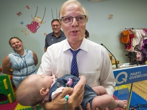 PQ leader Jean-Francois Lisee holds three-month-old Flavie Adam after announcing improvements to the parental leave plan while campaigning Wednesday, August 29, 2018 in Nicolet.