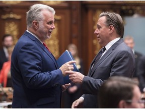 Quebec Premier Philippe Couillard, left, speaks with CAQ leader Francois Legault at the end of the spring session in 2015 at the legislature in Quebec City.