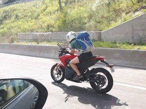 A photo posted to Facebook purports to show a motorcyclist using their cell phone while on the highway.