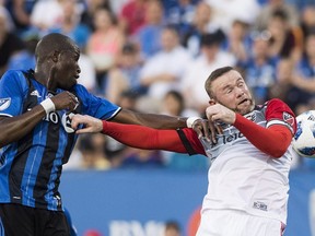 Montreal Impact's Rod Fanni, left, challenges D.C. United's Wayne Rooney during first half MLS soccer action in Montreal, Saturday, August 4, 2018.