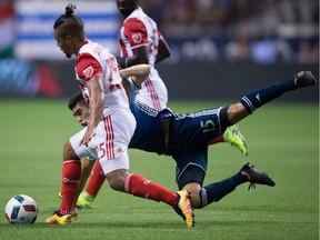 San Jose Earthquakes' Quincy Amarikwa, front left, and Vancouver Whitecaps' Matias Laba vie for the ball during the first half of an MLS soccer game in Vancouver, B.C., on Friday Aug. 12, 2016.