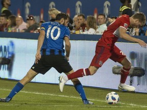 Montreal Impact's Ignacio Piatti forces Chicago Fire's Nicolas Hasler out of bounds as they battle for the ball during second half MLS action in Montreal on Saturday, August 18, 2018.