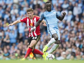 Manchester City's Bacary Sagna, right, fights for the ball against Sunderland's Lynden Gooch during English Premier League soccer match between Manchester City and Sunderland at the Etihad Stadium in Manchester, England, on Aug. 13, 2016.