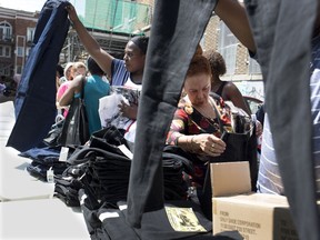 People go over the sizes of clothing at the annual back to school clothing give away at Sun Youth in Montreal on Tuesday August 14, 2018.