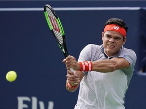 Milos Raonic of Canada returns a shot to Frances Tiafoe of the United States during second round Men's Rogers Cup tennis tournament action in Toronto on Wednesday, August 8, 2018.