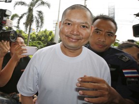 In this Thursday, July 20, 2017, file photo, ex-monk Wirapol Sukphol is escorted by the Department of Special Investigation officials to the prosecutor's office in Bangkok, Thailand. Wirapol, Wirapol, known for a jet-setting lifestyle, has been sentenced to over a hundred years in prison for deceiving his followers into making costly donations and embezzling the money. (AP Photo/Sakchai Lalit, File)