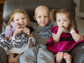 Marcus Hacault, age 6, is flanked by his younger siblings Julia, left, and Evelyn.