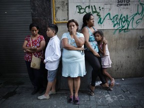Residents stand outside after a powerful earthquake shook eastern Venezuela, causing buildings to be evacuated in the capital of Caracas, Venezuela, Tuesday, Aug. 21, 2018. The quake was felt as far away as Colombia's capital and in the Venezuelan capital office workers evacuated buildings and people fled homes.