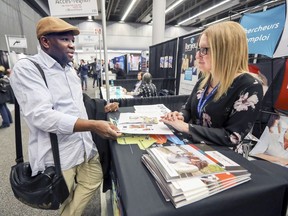 Ali Diaoune, originally from Guinea, speaks with Jessica Campeau from L'Orientheque, a workforce integration organization representing the Sorel-Tracy region, in the new section at Evenements Carriere aimed at helping new immigrants find jobs, at the Palais des Congres in Montreal Wednesday April 11, 2018.