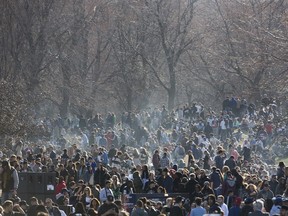 A cloud of smoke wafts over a crowd celebrating 4/20 at Mount Royal Park in Montreal, Wednesday, April 20, 2016.