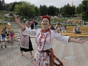 Women dressed in Ukrainian national clothes dance in a city park in Kiev.