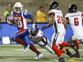 Montreal Alouettes running-back Tyrell Sutton breaks away from Ottawa Redblacks defenders in Montreal on July 6, 2018.