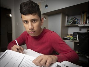 Alois Orozco goes through some of his schoolbooks from last year at home on Wednesday, September 12, 2018. Orozco has been at Royal West Academy since Grade 7, but might be forced to switch to a French school this year.