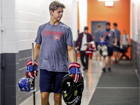 First-round draft choice Jesperi Kotkaniemi carries some gear while heading to have photos taken on the first day of the Canadiens' training camp at the Bell Sports Complex in Brossard on Thursday, Sept. 13, 2018.