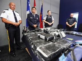 RCMP Inspector Jacques Rainville, left, Alain Surprenant, in charge of intelligence for Quebec region at the Canada Border Services Agency, and RCMP Cpl. Genevieve Byrne with 81 kilos of cocaine seized at the port in Valleyfield.