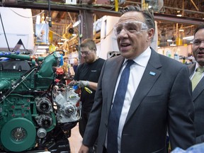 Coalition Avenir Québec Leader François Legault checks a motor during a visit to the Prevost assembly plant, Thursday, Sept. 27, 2018 in Ste-Claire.