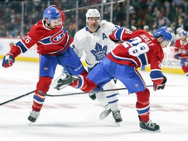 Defencemen Jeff Petry, left, and Mike Reilly collide with Toronto Maple Leafs' Patrick Marleau during first period in Montreal Wednesday, Sept. 26, 2018.