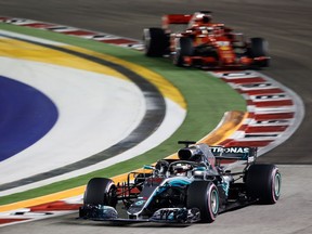 Lewis Hamilton of Great Britain driving the (44) Mercedes AMG Petronas F1 Team Mercedes WO9 leads Sebastian Vettel of Germany driving the (5) Scuderia Ferrari SF71H on track during the Formula One Grand Prix of Singapore at Marina Bay Street Circuit on September 16, 2018 in Singapore.