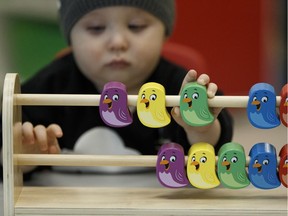 A toddler plays with bird blocks.