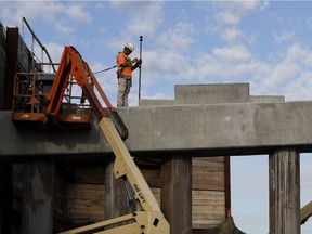 A worker checks the height of the pylons that will support the new Highway 15 south overpass at Atwater St. as part of the Turcot Interchange project in Montreal on July 3, 2018. The chunk of southbound Highway 15 that leads from the Turcot to Atwater Ave. is closed from Monday at 11 p.m. to Tuesday at 5 a.m. One out of two lanes in the span will be sealed off until Monday at 11 p.m.