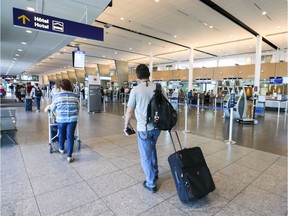 Travellers pull their luggage through the international departure level at Trudeau airport in Dorval.