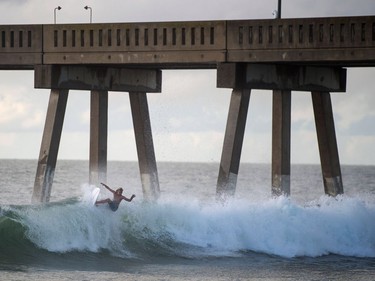 A surfer catches a wave a day before the arrival of Hurricane Florence at Wrightsville Beach, N.C., Sept 12, 2018.