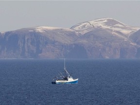 A lone fishing vessel sits anchored near Îles-de-la-Madeleine.