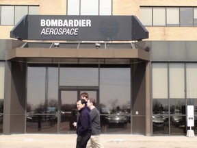 Employees walk past the front door of the Bombardier Aerospace office and plant in Downsview.