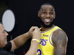 Los Angeles Lakers' LeBron James smiles as a microphone is placed on his chest during media day at the NBA basketball team's practice facility Monday, Sept. 24, 2018, in El Segundo, Calif.