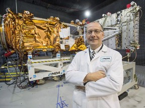 MDA's President Mike Greenley is seen in front of one of three RADARSAT Constellation Mission spacecrafts being built for the Canadian Space Agency at the company's facility in Sainte-Anne-de-Bellevue, Quebec on Tuesday January 30, 2018. With an eye on future lunar exploration, Canada's space agency is calling on companies to present their ideas for everything from moon-rover power systems to innovative mineral prospecting techniques.
