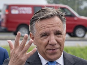 Coalition Avenir Quebec Leader Francois Legault responds to questions next to a busy highway in St-Hubert Sept. 18, 2018.