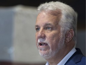 Quebec Liberal Leader Philippe Couillard responds to reporters questions during a visit of a cedar shingle plant in Saint-Prosper, Que., Thursday, Sept. 27, 2018.