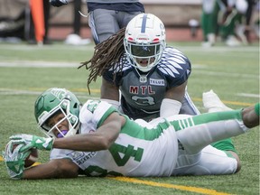 Roughriders' Jordan Williams-Lambert reaches in for a touchdown as Alouettes' Dominique Ellis looks on Sunday at Molson Stadium.