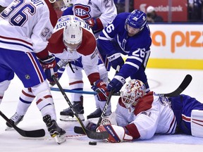 Toronto Maple Leafs centre Par Lindholm (26) looks for a loose puck by Montreal Canadiens goaltender Antti Niemi (37) as Canadiens Brett Lernout and Jacob de la Rose look on during second period NHL preseason action in Toronto, Monday, Sept. 24, 2018.