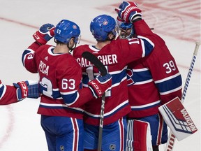 Canadiens' Brendan Gallagher and Matthew Peca congratulate goalkeeper Charlie Lindgren after winning 5-2 against the Capitals Thursday night in Quebec City.