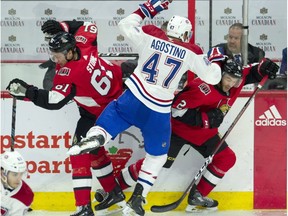 The Montreal Canadiens' Kenny Agostino collides with the Ottawa Senators' Mark Stone and defenceman Dylan DeMelo along the boards during third period NHL pre-season action Saturday, Sept. 29, 2018 in Ottawa.