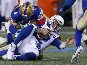 Montreal Alouettes QB Johnny Manziel is stopped on a run by Winnipeg Blue Bombers LB Adam Bighill (top) and Jovan Santos-Knox (bottom) Friday, Sept. 21, 2018, at Investors Group Field in Winnipeg.