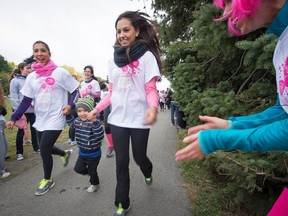 MONTREAL, QUE:  September,  30, 2012 -  Cynthia Enfante left, and Gesela Nunez right, hold onto young Aaron Nunez middle as they cross the finish line at the Annual, run for the cure, at Parc Maisonneuve in Montreal to raise money for breast cancer research Sunday, September 30, 2012,