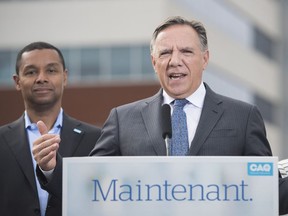 CAQ leader Francois Legault speaks to reporters alongside candidates Lionel Carmant, left, and Danielle McCann during a campaign stop in Vaudreuil-Dorion, Que., Sunday, September 2, 2018.
