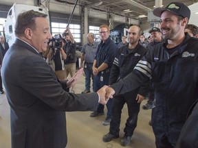 Coalition Avenir du Québec Leader François Legault greets mechanics during a visit to a trucking company while campaigning Thursday in Joliette.