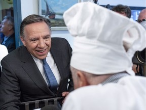 Coalition Avenir Québec Leader François Legault chats with the chef at a community centre during a campaign stop in Laval  on Tuesday, Sept. 11, 2018.