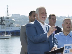 Quebec Liberal Leader Philippe Couillard, left, speaks at a news conference at a yacht club, Saturday, September 15, 2018 in Quebec City.
