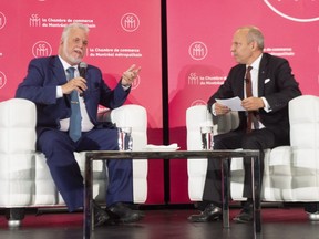 Liberal Leader Philippe Couillard speaks to Board of Trade president Michel Leblanc while campaigning Tuesday in Montreal.