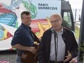 Working-class heroes: Parti Québécois Leader Jean-François Lisée, right, introduces Quebec singer Daniel Boucher, who dedicated a song to the PQ and its colourful campaign bus, Monday, Sept. 3, 2018 during a campaign stop in Ste-Anne-des-Monts.
