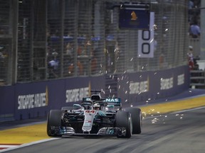 Sparks fly from the rear Mercedes driver Lewis Hamilton of Britain during qualifying at the Marina Bay City Circuit ahead of the Singapore Formula One Grand Prix in Singapore, Saturday, Sept. 15, 2018.