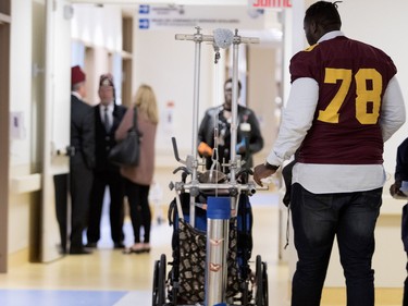 At 6-foot-8, Maurice Simba of the Concordia Stingers towers over 5- year-old Garron Clarke as they walk the hallways at the Shriners Hospital for Children in Montreal on Wednesday, Sept. 26, 2018. The Stingers visited with patients at the hospital before hosting the 32nd edition of the Shrine Bowl fundraising game on Saturday at 2 p.m. against the Université de Laval Rouge et Or. The Karnak Shriners, organizers of the event, announced that this year the Shrine Bowl will reach $1 million raised since its inception in 1987.