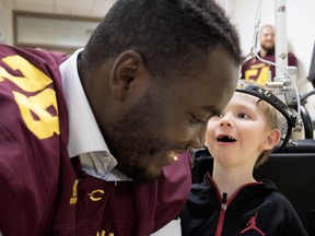 Maurice Simba of the Concordia Stingers listens as Garron Clarke, 5, whispers to him at the Shriners Hospital for Children in Montreal on Wednesday, Sept. 26, 2018.