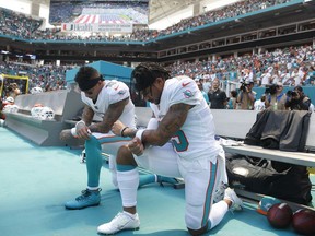 Miami Dolphins wide receiver Kenny Stills (10) and Miami Dolphins wide receiver Albert Wilson (15) kneel during the national anthem before an NFL football game against the Tennessee Titans, Sunday, Sept. 9, 2018, in Miami Gardens, Fla.