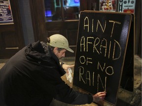 Nick Eberlein, bartender at The Merry Widow, draws a new sign as Tropical Storm Gordon arrives during the night in Mobile, Ala., Sept. 4, 2018.